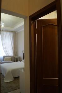 an open door to a bedroom with a bed and a window at Schastie na Rubinsteina - Apartments in Saint Petersburg