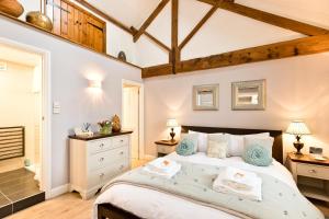 a bedroom with a large bed with blue accents at Juniper Cottage in Bakewell
