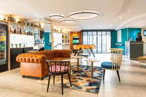 a restaurant with a couch and tables and chairs at ibis Paris Gare de Lyon Diderot in Paris