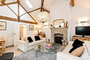 a living room with white furniture and a fireplace at Juniper Cottage in Bakewell