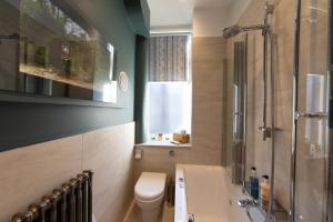 uma casa de banho com um WC, um chuveiro e um lavatório. em The Jeffrey Street Retreat em Edimburgo
