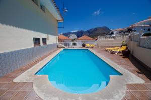 a swimming pool on the side of a house at Residencial Arena del Sol 6 by Olax Rentals in Puerto de Santiago