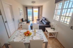 a living room with a table with a bowl of fruit on it at Residencial Arena del Sol 6 by Olax Rentals in Puerto de Santiago