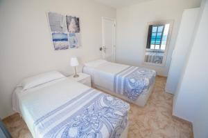 a bedroom with two beds and a mirror at Residencial Arena del Sol 6 by Olax Rentals in Puerto de Santiago +6 photos