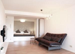 a living room with a couch in front of a bed at Engen Apartment in Engen