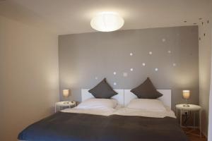 a bedroom with a large bed with two lights on it at Engen Apartment in Engen