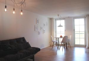a living room with a couch and a table and chairs at Engen Apartment in Engen