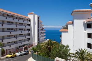 a view of the ocean from between buildings at Residencial Arena del Sol 6 by Olax Rentals in Puerto de Santiago