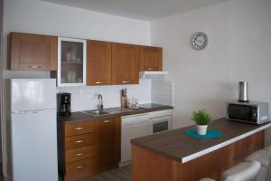 カジャオ・サルバヘにあるAncla views FREE WIFIのキッチン(木製キャビネット、白い冷蔵庫付)