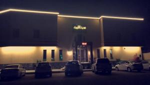 een gebouw met auto's geparkeerd op een parkeerplaats 's nachts bij Durat Al Lith Chalet in Al Lith