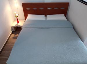 a bed with white sheets and a wooden head board at Valentina 16/18 Rue rouaze cannes in Cannes