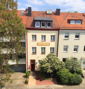 a large white building with a red roof at Design-Boutique Hotel Vosteen in Nürnberg