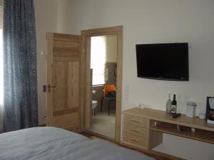 a bedroom with a bed and a television on a wall at Exklusive Gästezimmer Landau in Landau in der Pfalz