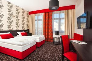 Pokój hotelowy z 2 łóżkami, biurkiem i krzesłem w obiekcie Cottonina Hotel & Mineral SPA Resort w Świeradowie Zdroju