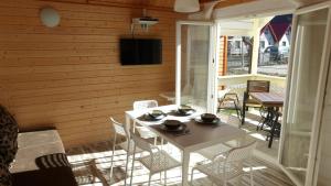 a white table and chairs on a porch with a television at Ada.Vacations in Ustronie Morskie