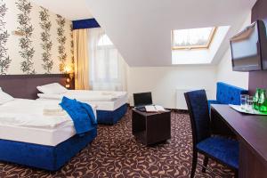 ein Hotelzimmer mit 2 Betten und einem TV in der Unterkunft Cottonina Hotel & Mineral SPA Resort in Świeradów-Zdrój