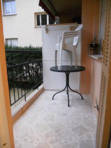 Un balcón con una silla y una mesa en location saisonnière, en Menton
