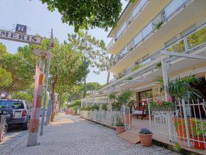 a street in front of a building with plants at Hotel Meris in Milano Marittima