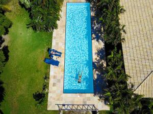 an overhead view of a swimming pool with two people in it at Refúgios Parajuru - Villa Cristiano in Parajuru