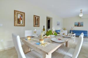 een eetkamer met een houten tafel en witte stoelen bij Alexandras Forest View in Ágios Prokópios
