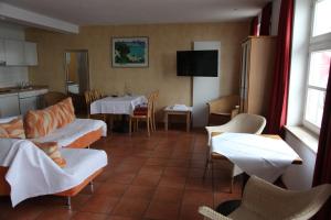 een woonkamer met een tafel en stoelen en een keuken bij Hotel Bacchus Wine & Bites in Meersburg