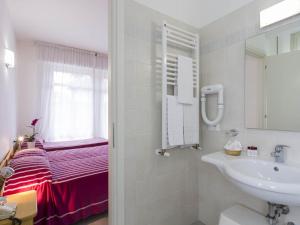 a bathroom with a sink and a bed at Hotel Meris in Milano Marittima