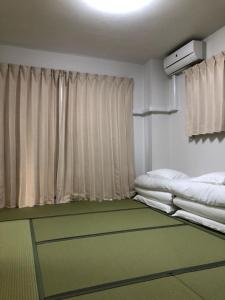 a room with two beds and a window at First Hongo Building 202 / Vacation STAY 3355 in Chiba