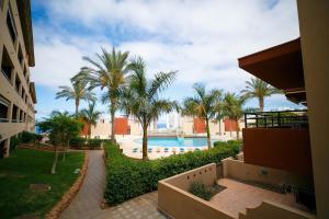 une vue sur une piscine et des palmiers dans l'établissement Spacious and comfortable Paraiso II, à Playa Paraiso 31 autres photos