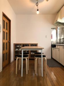 a kitchen with a table and some stools at First Hongo Building 202 / Vacation STAY 3355 in Chiba