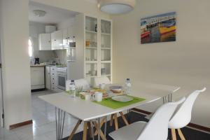 a kitchen and dining room with a white table and chairs at Holiday in the Algarve - Tavira Garden T1 in Tavira