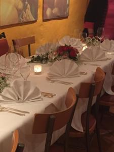 einen Tisch mit weißen Tischdecken und Blumen darauf in der Unterkunft Hotel Bacchus Wine & Bites in Meersburg