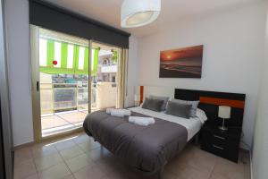a bedroom with a large bed with a large window at DIFFERENTFLATS Decathlon in Salou