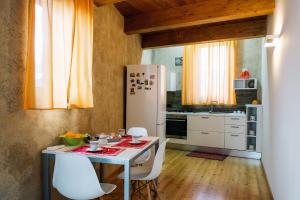 a kitchen with a table and a white refrigerator at Al Maratoneta in Linguaglossa