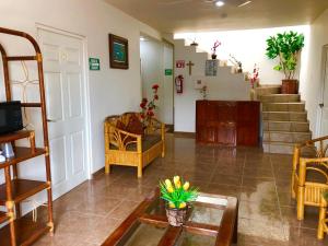 a living room with stairs and chairs and a table at Hostal Cristo Rey in Ciudad Valles