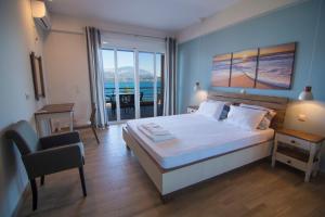 a bedroom with a bed with a view of the ocean at Loggos view apartments in Lixouri