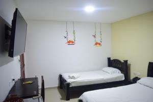 a room with two beds and a flat screen tv at Hotel Intersuites in Barranquilla