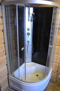 a shower with a glass door in a bathroom at sodyba "Vilkasalė" in Mindūnai