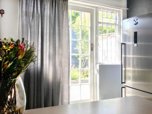 a kitchen with a refrigerator and a window at Milnerton Cottage in Cape Town