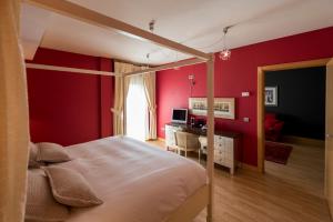 a bedroom with red walls and a bed and a desk at Itaca Salamanca by Soho Boutique in Salamanca