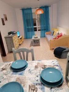 uma sala de estar com uma mesa com pratos azuis em Vivienda cercana a la playa con todas las comodidades em Tarifa