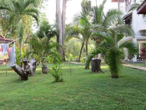 a park with palm trees in the grass at Villa Lanka Relax in Hikkaduwa