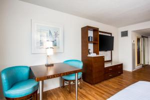 a hotel room with a desk and blue chairs at Margaritaville Lake Resort Lake of the Ozarks in Osage Beach