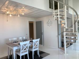 a dining room with a table and a spiral staircase at Vista mare in Viareggio
