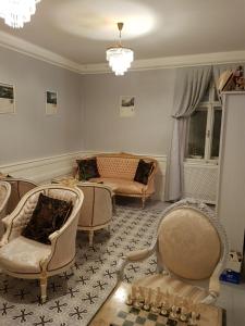 una sala de estar con sofás, sillas y una lámpara de araña. en Villa Vodicka, en Piešťany