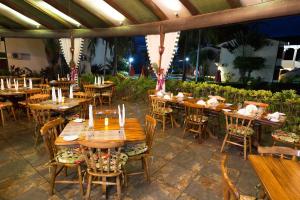 eine Gruppe von Tischen und Stühlen in einem Restaurant in der Unterkunft Club del Mar Oceanfront in Jacó