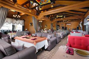 een restaurant met banken en tafels in een kamer bij Hotel Park Rodnik in Pyatigorsk