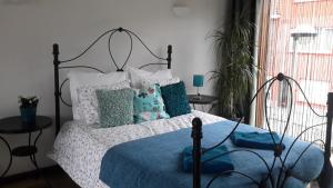 een slaapkamer met een bed met een blauwe deken en kussens bij Harmony House in Antwerpen +2 foto's