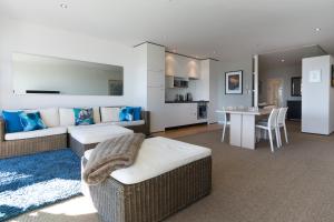 een woonkamer met een bank en een eetkamer bij Latitude Waterfront Apartment in Nelson