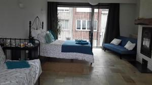 a bedroom with a bed and a couch and a window at Harmony House in Antwerp