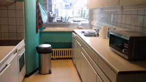 a kitchen with a sink and a microwave on a counter at Harmony House in Antwerp
